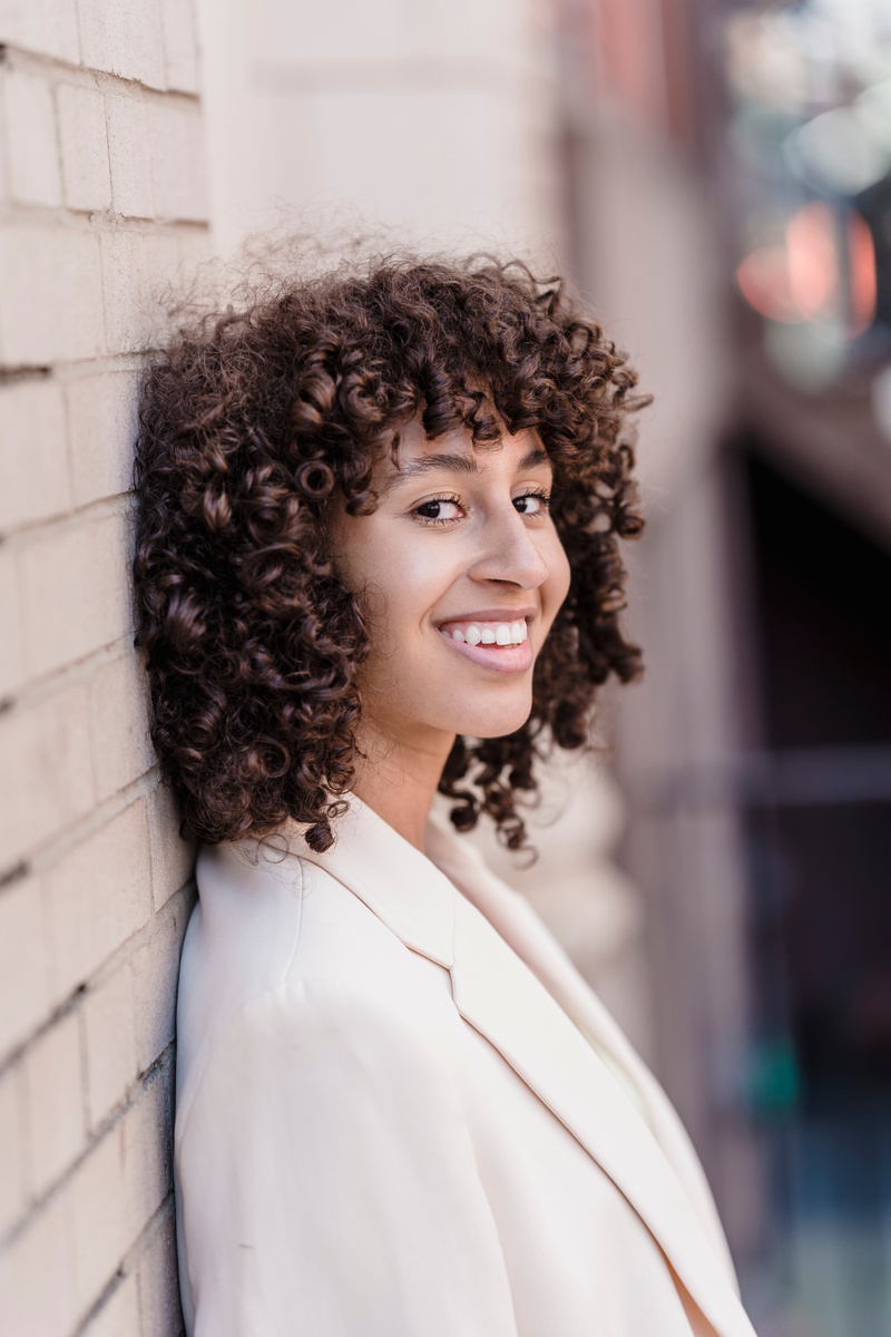 A Woman Wearing a Blazer Leaning on a Wall